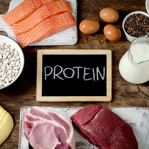 kitchen counter with raw salmon, eggs, milk, steak and a chalk board sign