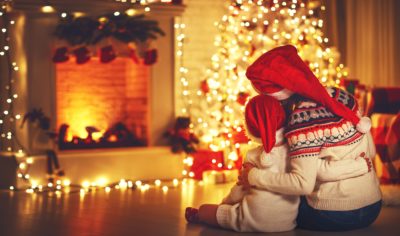 grand mother sitting with grandson by the Christmas tree