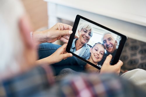senior couple talking to family on a tablet over zoom