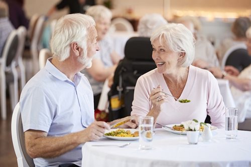 senior couple eating dinner laughing